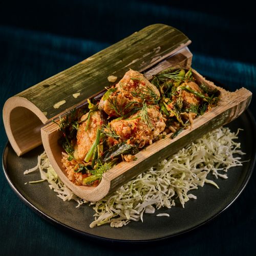 Baked fish with herbs in bamboo.